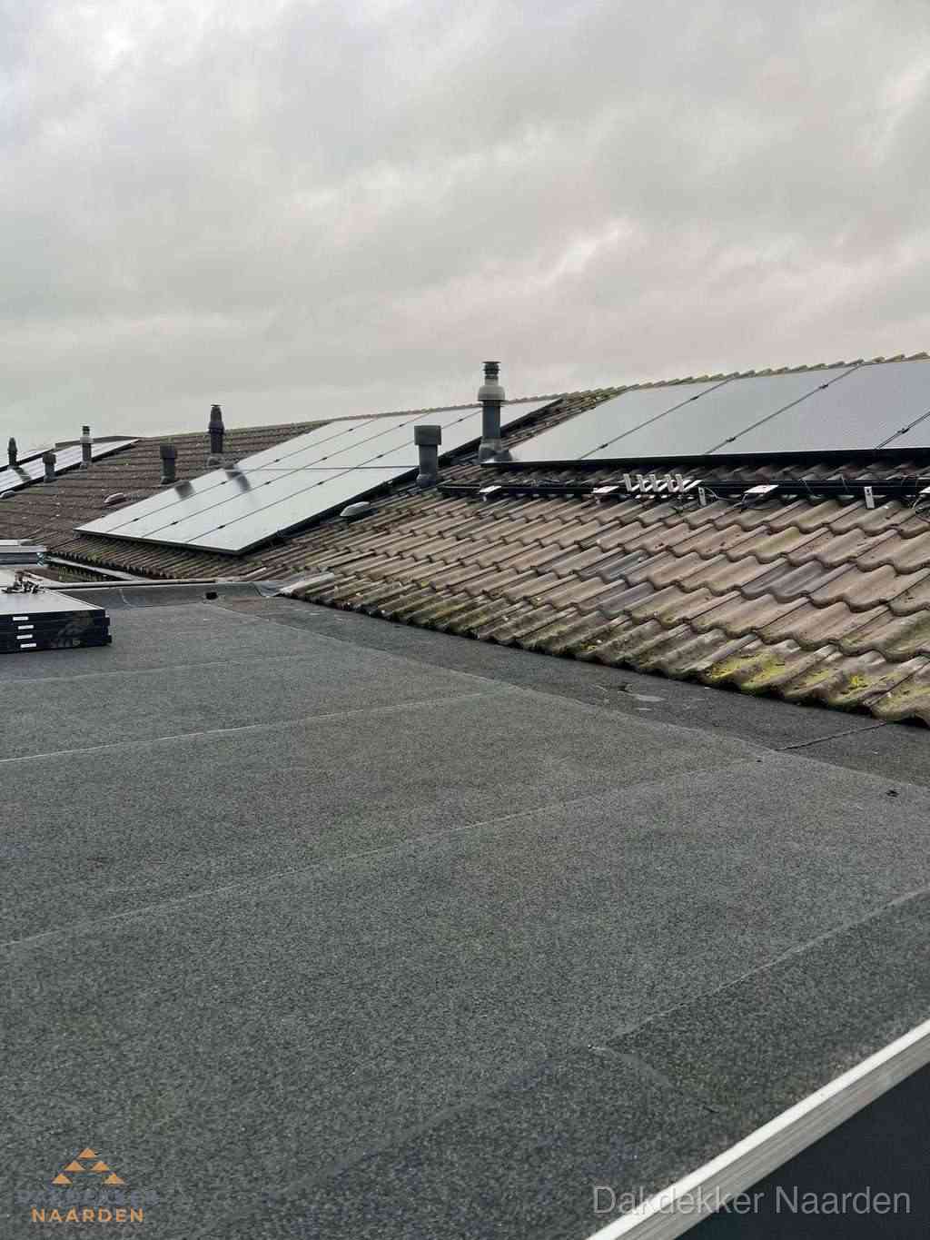Bitumen dakbedekking op plat dak met aansluitend pannendak en zonnepanelen in Naarden