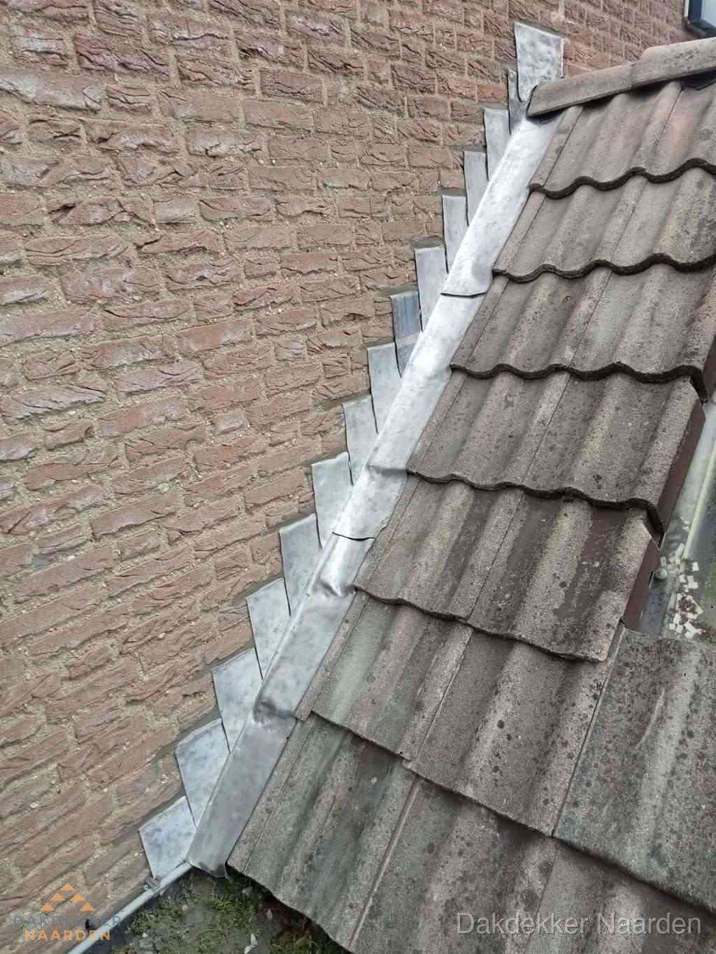 Loodslabben langs dakaansluiting bij bakstenen muur in Naarden